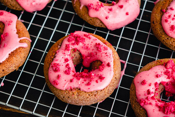 Raspberry Baked Donuts with Raspberry Glaze on a Wire Cooling Rack: Baked donuts with pink...