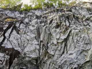 View from the water on the steep slope of the flooded Marble Canyon in the Ruskeala Mountain Park on a sunny summer day.