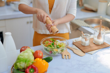 Closeup mid section of a chef putting salt and Pepper in the kitchen