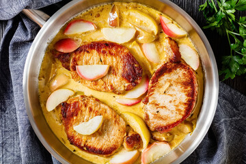 pork chops in apple cider cream sauce in a pan