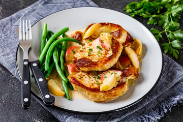 pork chops in apple cider cream sauce on a plate