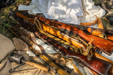 Military machine gun lies on the dry grass in the field