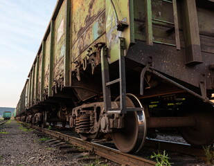 Old rusty railway cars stand on the tracks of the station