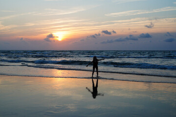 Liberté sur la plage, devant un coucher de soleil sur l'océan Atlantique