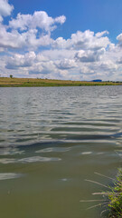Landscape with a lake and clouds in the sky in the summer season