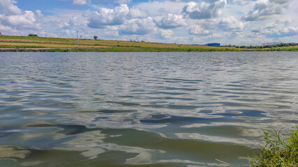 Landscape with a lake and clouds in the sky in the summer season