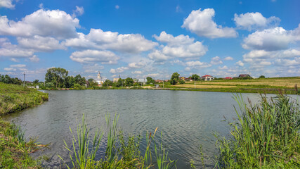 Landscape with a lake and clouds in the sky in the summer season