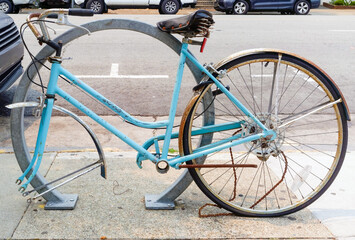 Gutted bike locked to parking meter missing tire.
