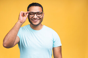 Portrait of a cheerful young african american indian black man standing isolated over yellow background.