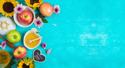 Jewish holiday Rosh Hashana background with honey, apple and sunflowers on blue wooden table. Top...