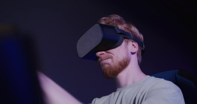 A red-haired guy in virtual reality glasses controls the simulator in 5D