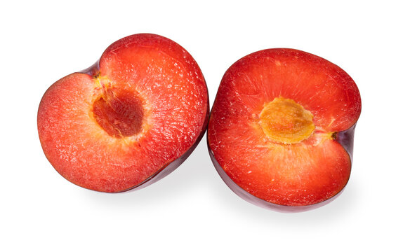 Two halves of a red plum isolated on a white background.Plum slice with a stone on a white background.