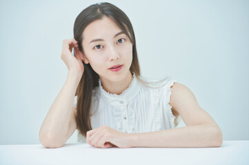 肘をつくポーズをする若い女性