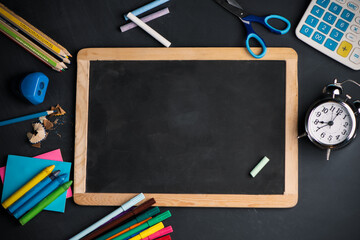 A blackboard on wood background with School supplies
