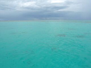 Moorea, French Polynesia: dark rain season clouds over blue lagoon forecast approaching tropical storm,