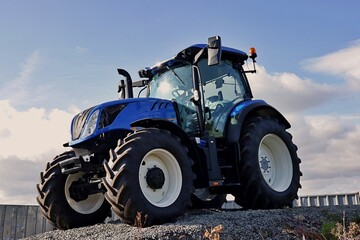 New farm tractor  on a blue colour.