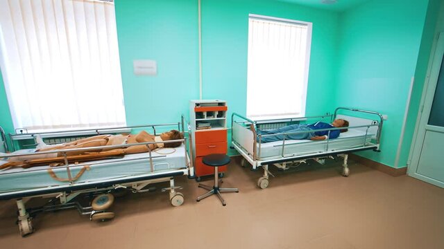 Modern room with human mannequins for medical practices. Medical room with female dummies laying in beds for teaching treatment in university.