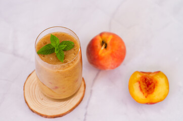Top view of fresh healthy smoothie in a glass made of peach, banana and berries. Creative concept of healthy detox drink, diet or vegetarian food concept. Copy space.