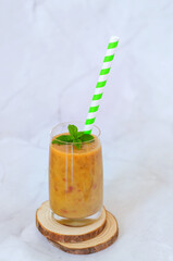 Top view of fresh healthy smoothie in a glass made of peach, banana and berries. Creative concept of healthy detox drink, diet or vegetarian food concept. Copy space.