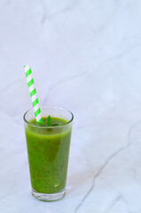Top view of fresh green healthy smoothie in a glass made of kiwi, chia seeds and banana with mint. Creative concept of healthy detox drink, diet or vegetarian food concept. Copy space.