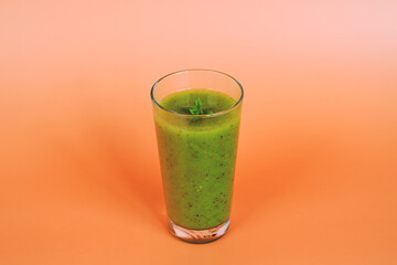 Top view of fresh green healthy smoothie in a glass made of kiwi, chia seeds and banana with mint. Creative concept of healthy detox drink, diet or vegetarian food concept. Copy space.