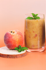 Top view of fresh healthy smoothie in a glass made of peach, banana and berries. Creative concept of healthy detox drink, diet or vegetarian food concept. Copy space.