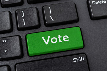 Vote green key on a black pc keyboard. Online participation in elections, internet voting and...