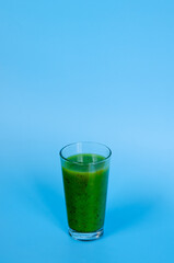 Top view of fresh green healthy smoothie in a glass made of kiwi, chia seeds and banana with mint. Creative concept of healthy detox drink, diet or vegetarian food concept. Copy space.