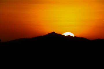 Obraz premium sunset in the mountains with hiding sun