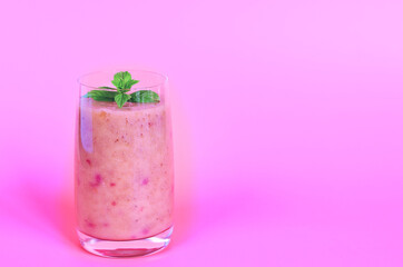 Top view of fresh healthy smoothie in a glass made of peach, banana and berries. Creative concept of healthy detox drink, diet or vegetarian food concept. Copy space.