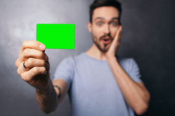Man tattoo hold plastic discount credit card shopper beard shocked surprised european dressed plain...