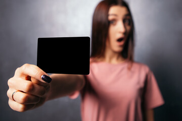 Woman hold plastic discount credit card shopper beard showing thumb up shocked open mouth european dressed plain t-shirt shopping buyings sales black friday concept copy space mock up 