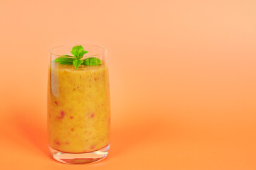 Top view of fresh healthy smoothie in a glass made of peach, banana and berries. Creative concept of healthy detox drink, diet or vegetarian food concept. Copy space.