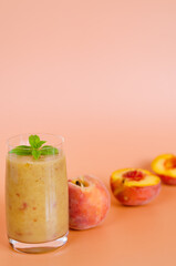 Top view of fresh healthy smoothie in a glass made of peach, banana and berries. Creative concept of healthy detox drink, diet or vegetarian food concept. Copy space.