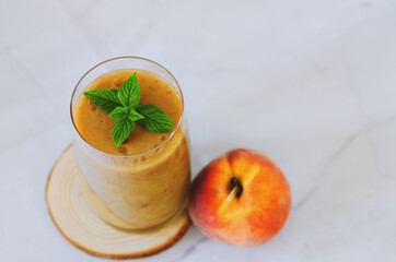 Top view of fresh healthy smoothie in a glass made of peach, banana and berries. Creative concept of healthy detox drink, diet or vegetarian food concept. Copy space.