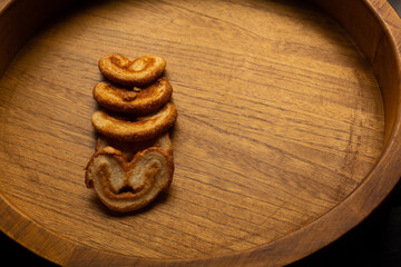 top view of many delicious freshly baked puff pastry ears on a wood colored board