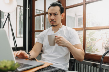 Serious face of Asian man concentrate on his work in the laptop.