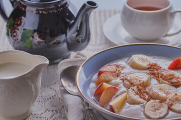 Fototapeta premium Breakfast table image with tea,porridge and fruits.