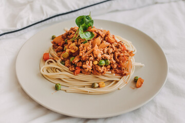 Homemade Spaghetti sauce with ground pork served in white dish.
