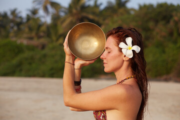 Woman with singing  tibetian bowl in hands