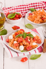 Fusilli pasta with cherry tomatoes and mozzarella cheese.
