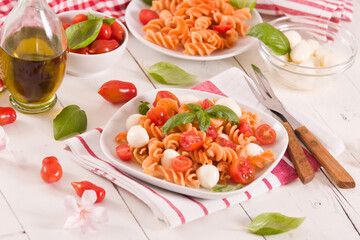 Fusilli pasta with cherry tomatoes and mozzarella cheese.