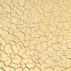 Surface of dried lake bed with cracks in mud, natural background