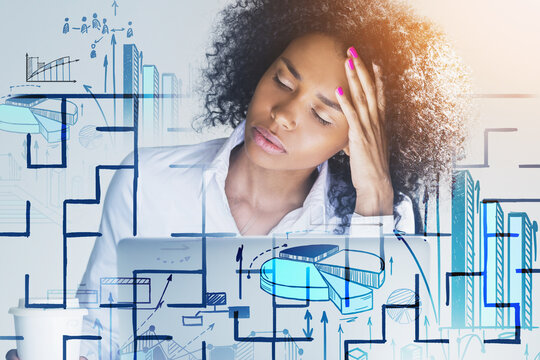 Thoughtful African American businesswoman wearing white shirt is sitting