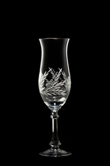 An empty champagne glass on a black background.