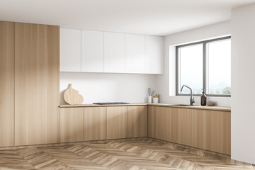 Modern white kitchen corner with wood materials and window over a sink