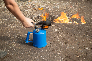 A gasoline blowtorch.Using a gasoline blowtorch for repairs.