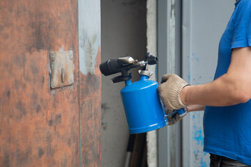 A gasoline blowtorch.Using a gasoline blowtorch to clean old paint from metal surfaces. Preparation...