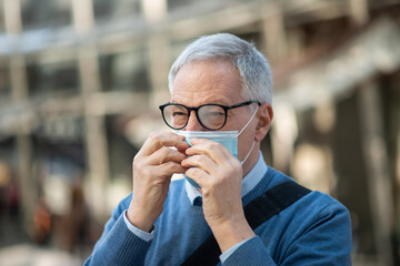 Man showing his eyeglasses fogged due to the mask, covid coronavirus vision concept