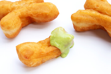 Deep-fried dough stick or chinese bread stick with steamed custard on white background.